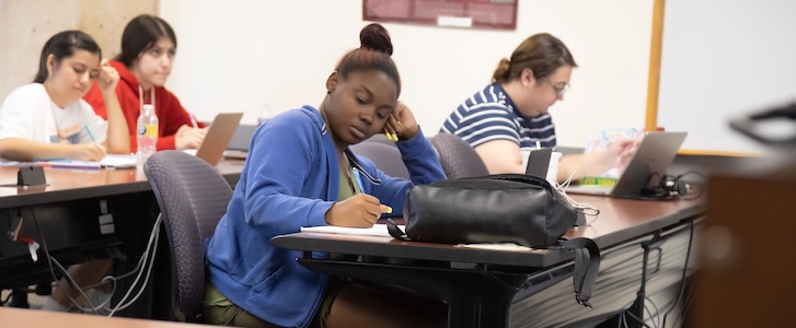 Person writing notes during class Person writing notes during class